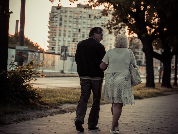 couple walking on sidewalk during daytime