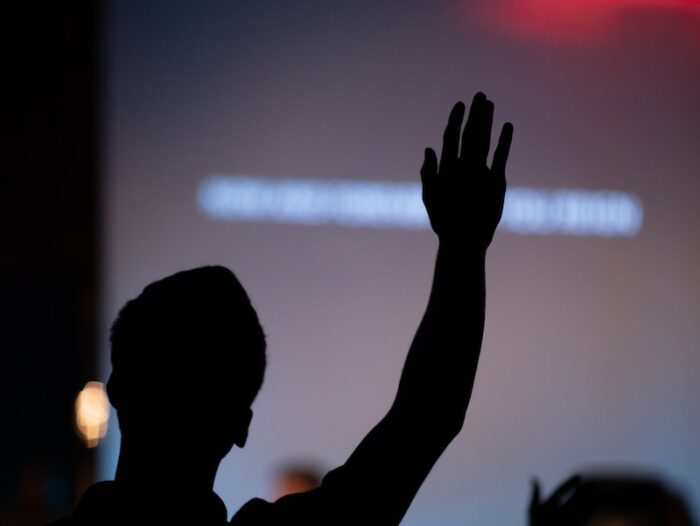 silhouette of person raising hand