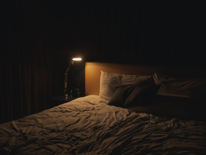 table lamp turned-on near bed