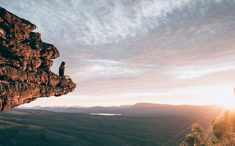 man sitting on mountain rock